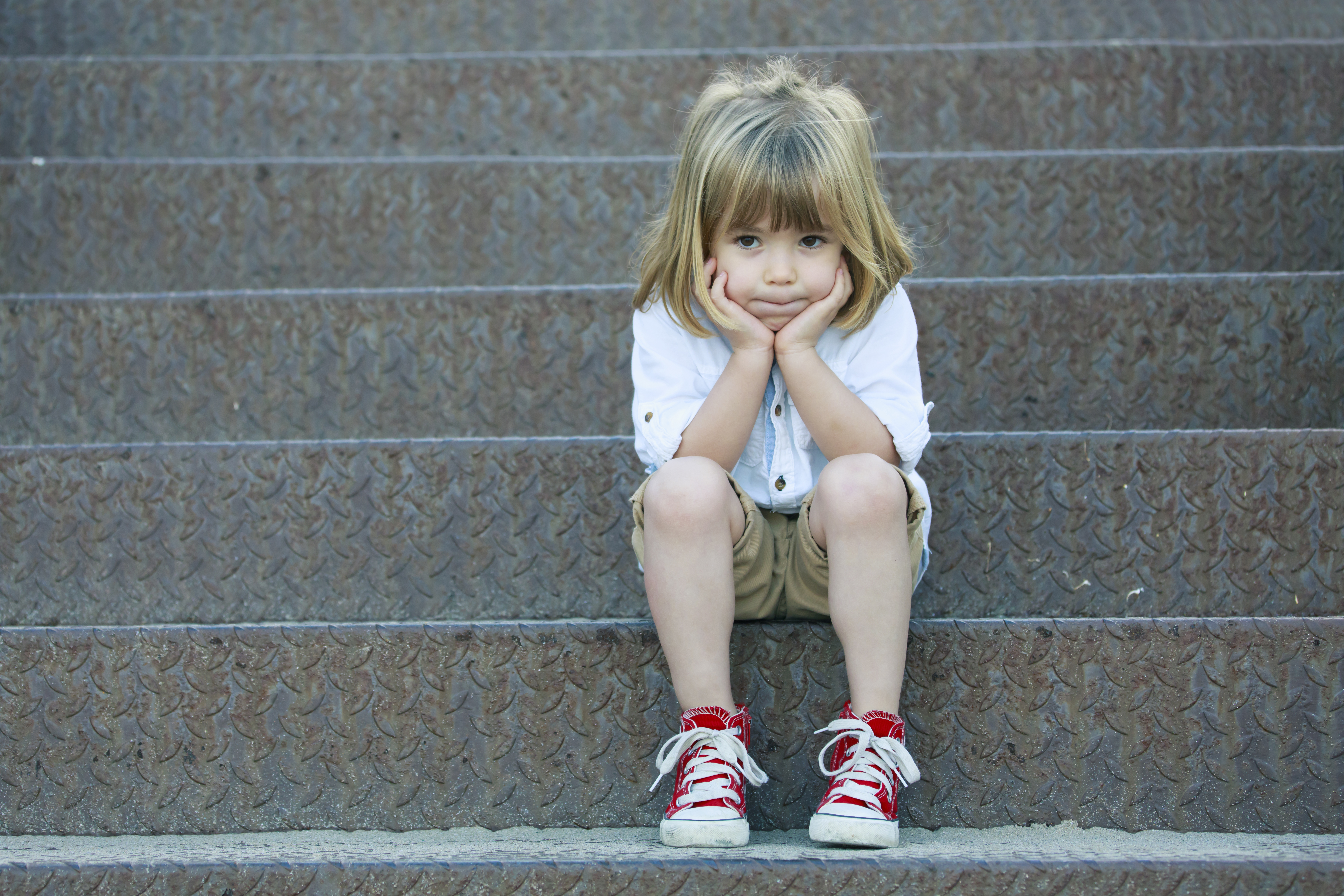 Sad boy sitting on staircase Sad little boy sitting on staircase.