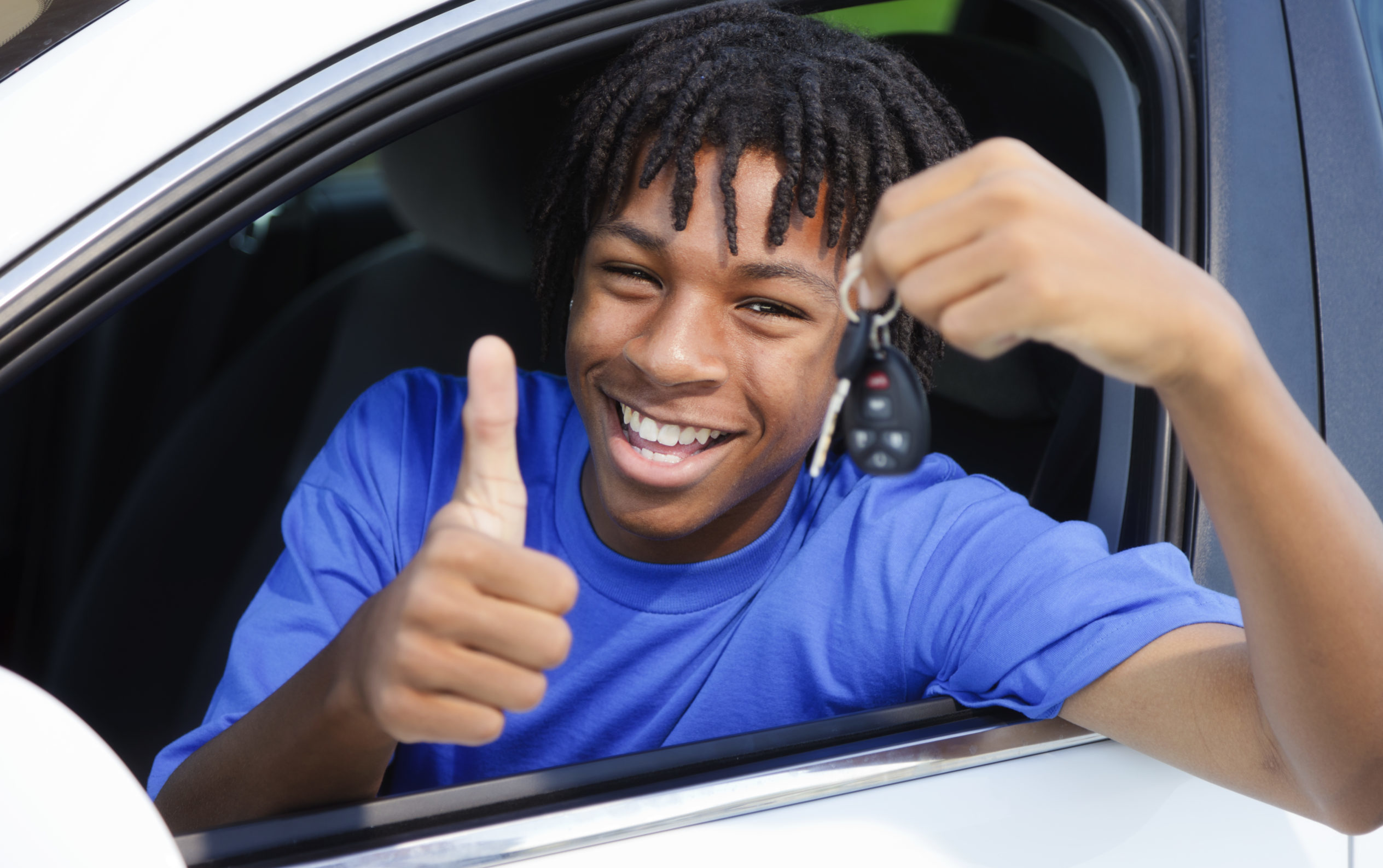 A teenage boy celebrating that he passed his driver's test.